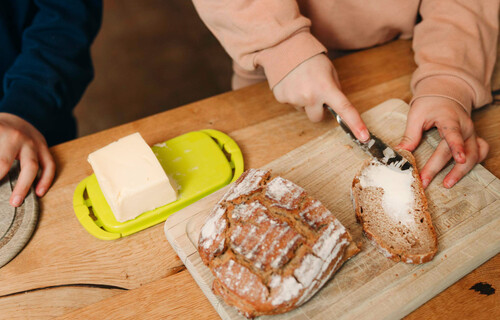 Kinderhände schmieren Butterbrot | © Land schafft Leben