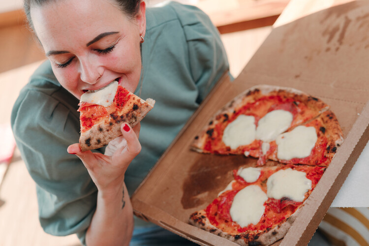 Frau beißt in Pizza | © Land schafft Leben