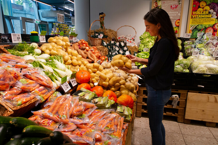 Dunkelhaarige Frau hält Sack Kartoffeln im Supermarkt | © Land schafft Leben