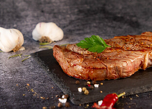 Rindersteak gebraten auf Teller mit Knoblauch und Petersilie | © Land schafft Leben